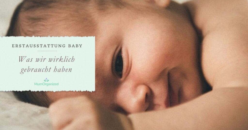Neugeborenes Baby liegt wach auf einer hellen Decke und lächelt